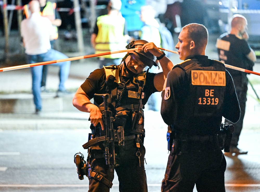 Armed police stand near the scene where one person was killed and around 16 injured after a car struck people on the outskirts of the Christopher Street Day (CSD) parade in Berlin, on July 25, 2026 (AFP/Getty)