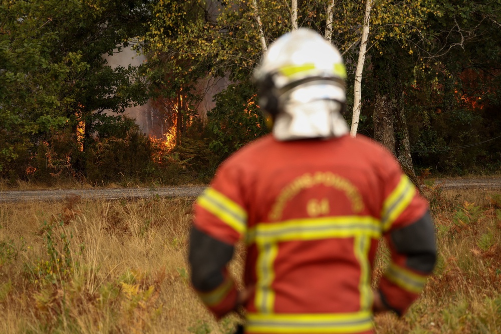 A firefighter stands on the edge of a burning area in Blagon, west of Bordeaux, on July 26, 2026 as a wildfire has been ravaging the forest north of the Arcachon Basin (Gironde) since July 22. (AFP/Getty)