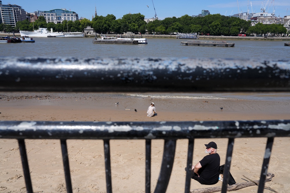 People sit beside the River Thames amid soaring temperatures earlier in July (AFP/Getty)