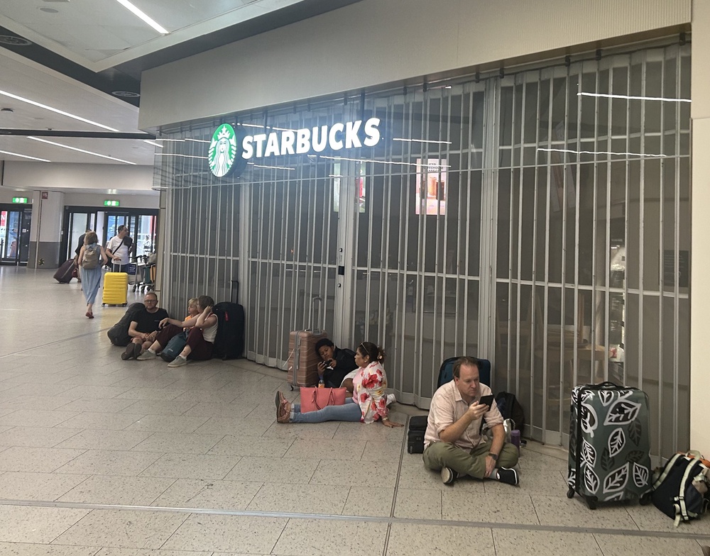 People sit outside the closed Starbucks at Gatwick airport (Tom Jeffreys/PA) (PA Wire)
