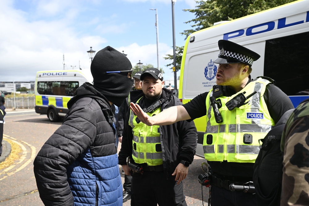 A police officer speaks to a protester during an anti-immigration protest in Glasgow (Lesley Martin/PA) (PA Wire)