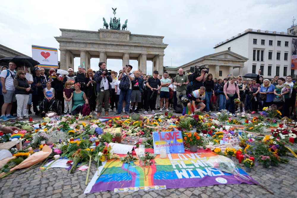 People gather outside the Brandenburg Gate for a demonstration in support of LGBTQ+ after a car rammed into a crowd at the Pride March in Berlin (AP)