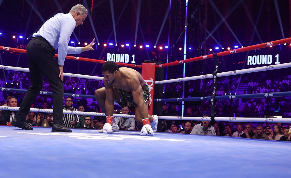 Anthony Joshua climbing off the canvas after one of two first-round knockdowns (Getty)
