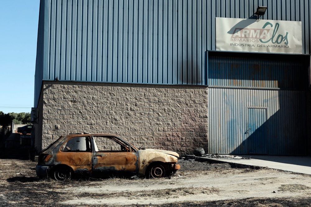 A burnt-out vehicle is seen following a wildfire in Chapineria, 50km west of Madrid (AFP/Getty)