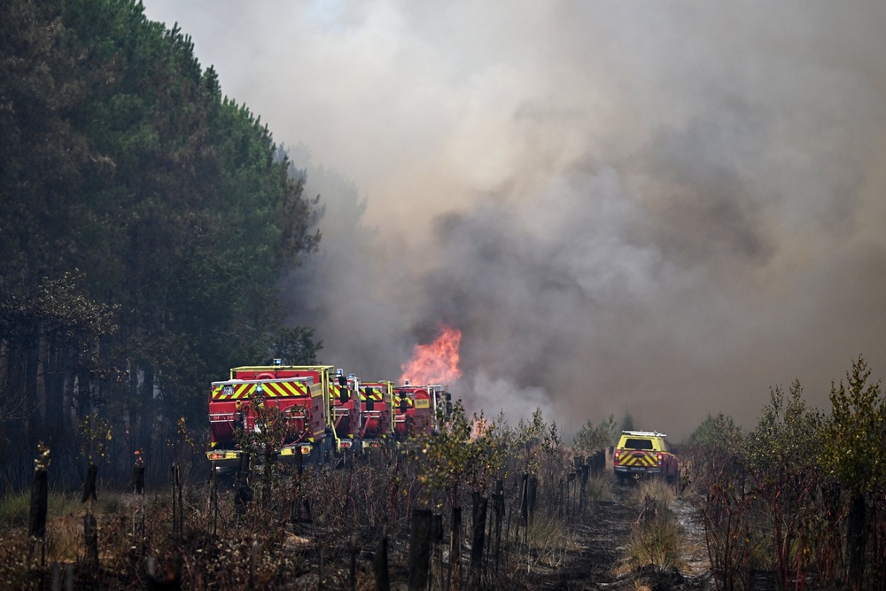 Firefighters tackle a blaze as wildfires rage near Le Las, outside Bordeaux on Monday (AP)
