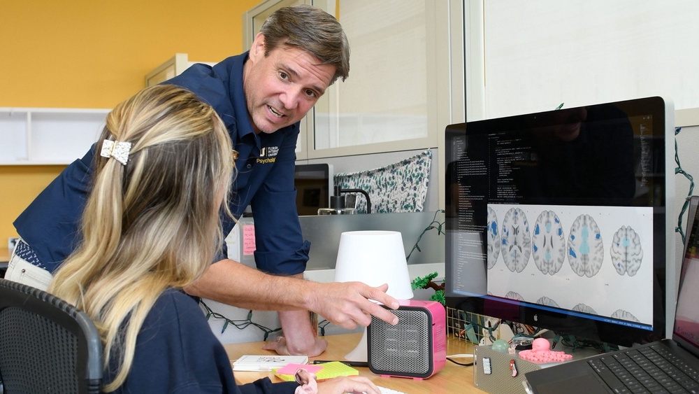 Matthew Sutherland, director of Florida International University’s Neuroinformatics and Brain Connectivity Lab and Chloe Hampson, a graduate student co-author of the study review brain images of regions communicating with brain areas showing structural changes linked with sleep disorders (Taimy Alvarez)