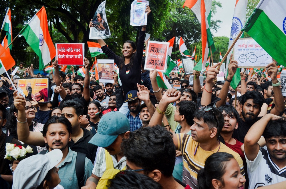 Cockroach Janta Party (CJP) supporters chant slogans, hold placards and wave national flag as they celebrate the resignation of education minister Dharmendra Pradhan (Reuters)