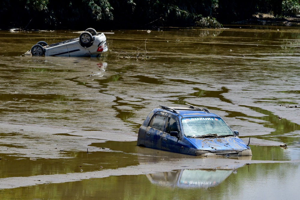 Cars partially submerged in muddy floodwater after a severe flood hit in Sivasagar (Reuters)