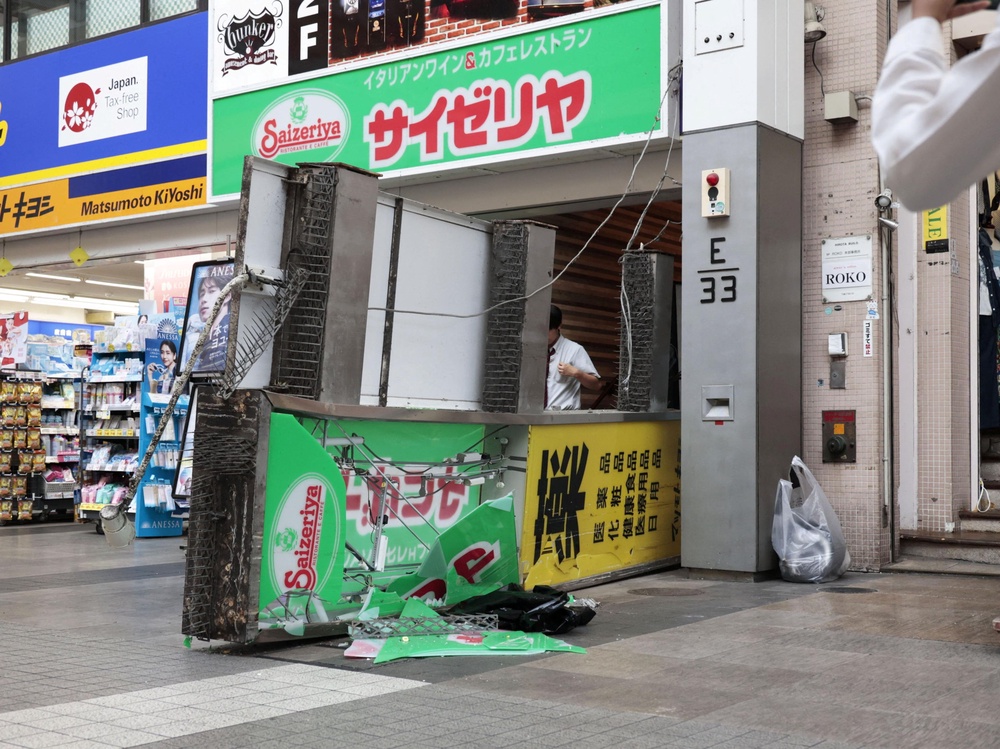 A damaged fallen signboard outside a Saizeriya restaurant (Reuters)