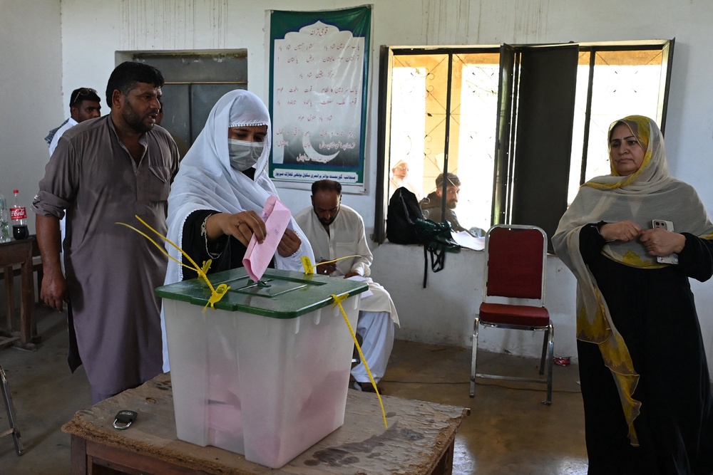 A woman casts her ballot at a polling station during the first phase of regional elections in Pakistan-administered Kashmir's Mirpur on 27 July 2026 (AFP/Getty)