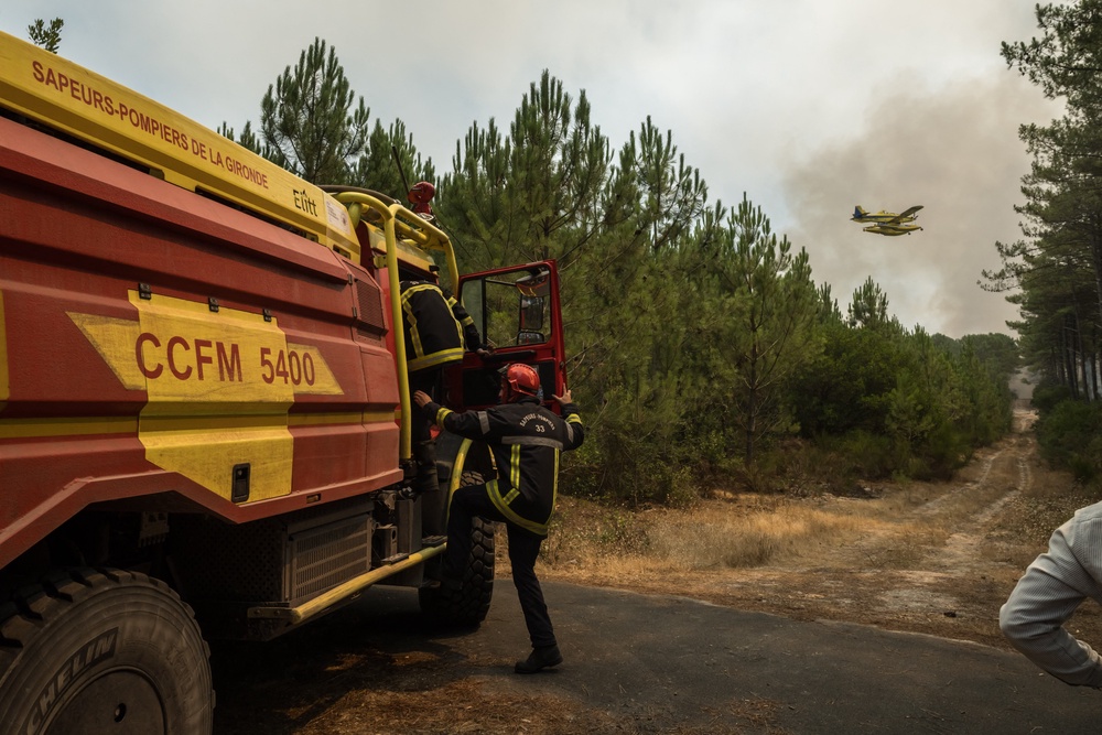 An Air Tractor AT-802 aircraft flies over smoke rising from a forest fire in southwestern France (AFP/Getty)