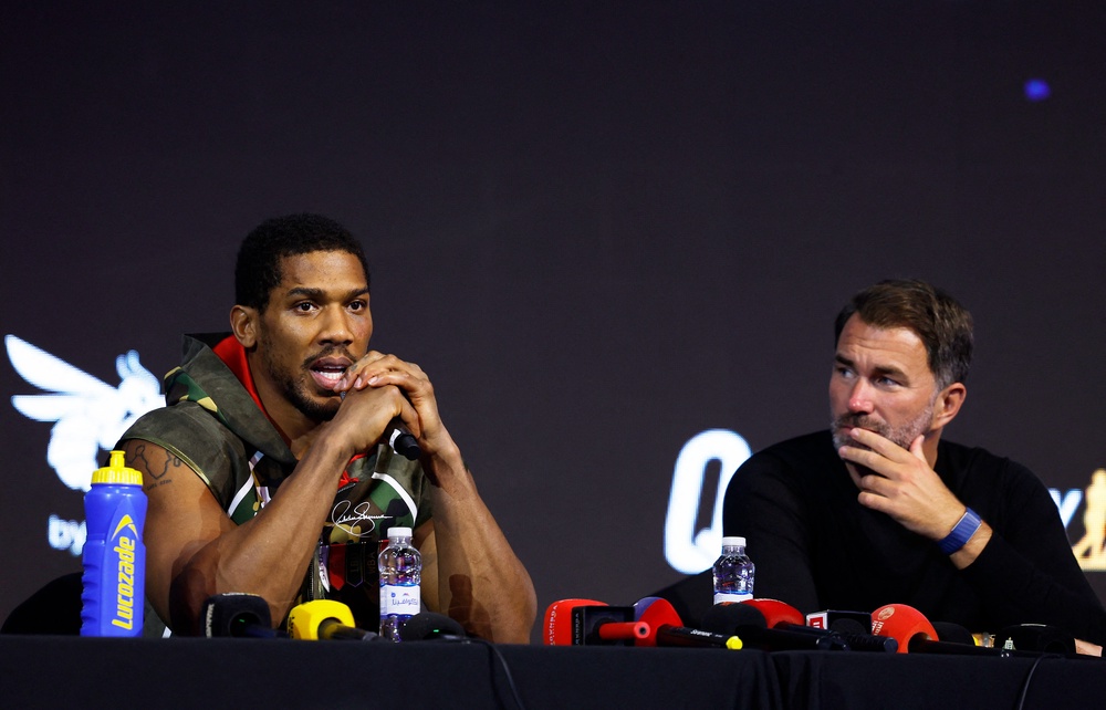 Joshua with his promoter Eddie Hearn at Saturday’s post-fight press conference (Reuters)