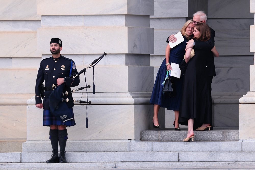 People embrace in front of a bag piper after attending a memorial tribute for the late Sen. Lindsey Graham (Getty Images)
