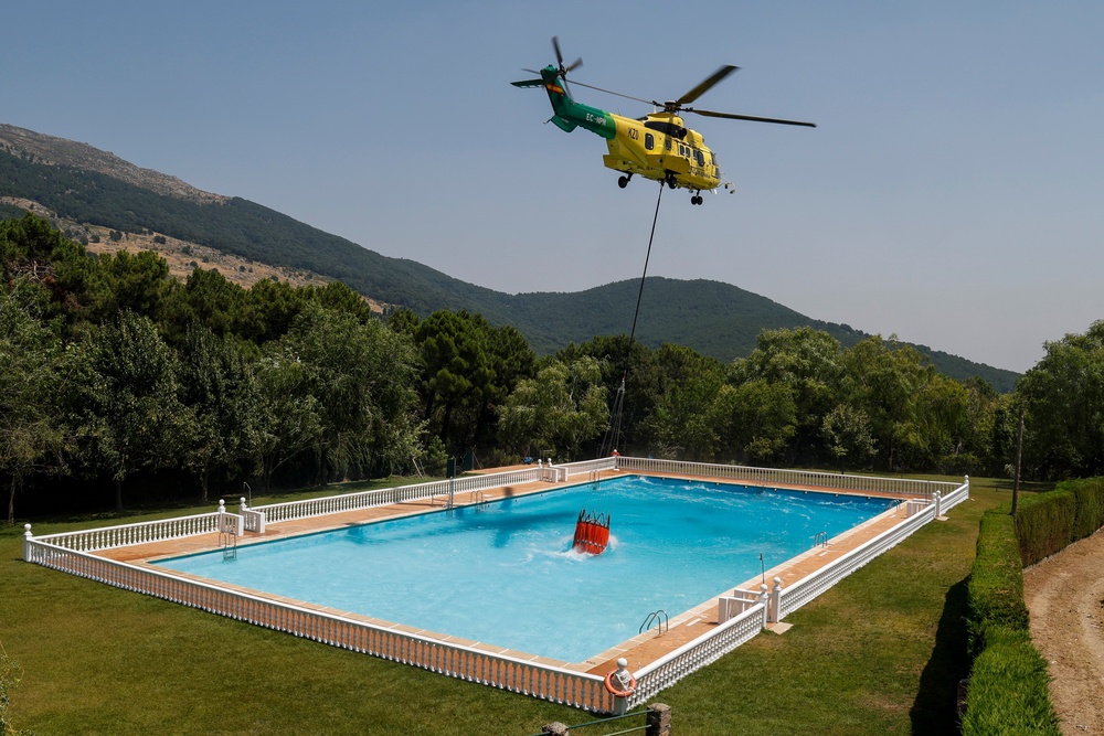 A helicopter collects swimming pool water (Getty)