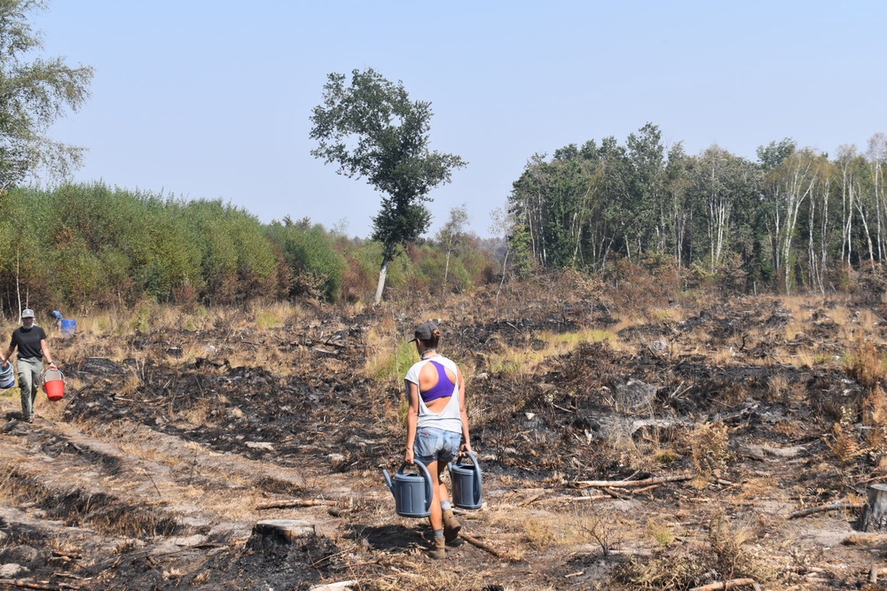 Lacanau residents carried buckets of water into the devastated landscape to help put out fires themselves (James Reynolds / The Independent)