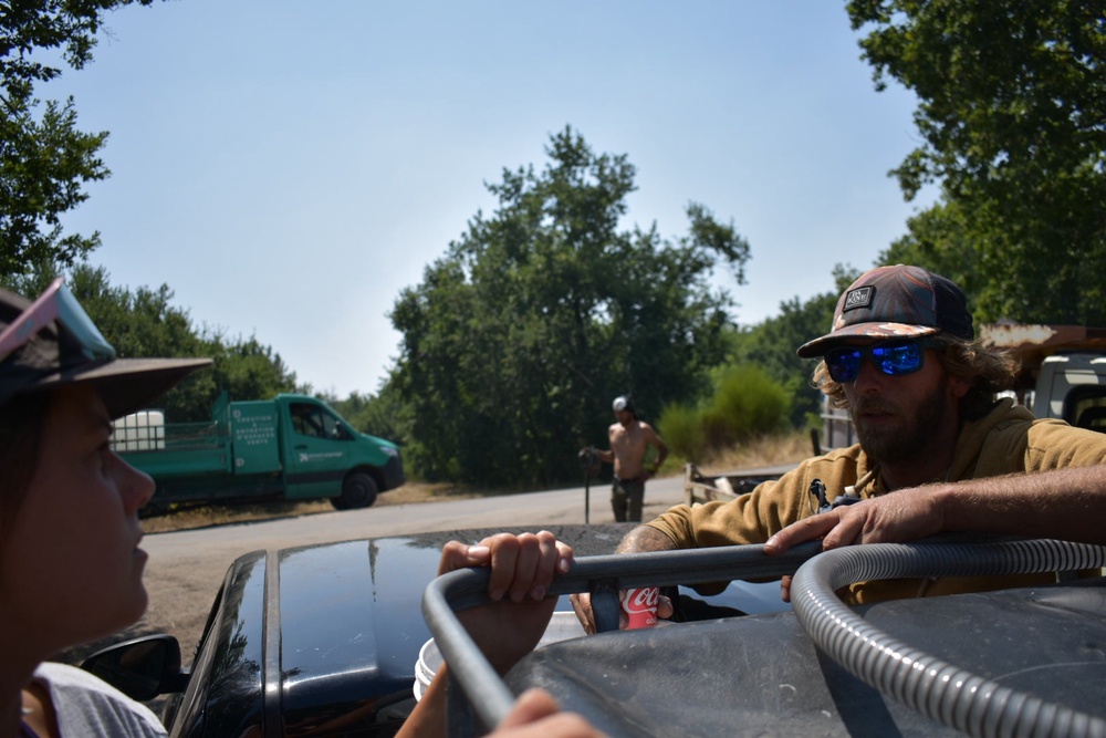 A patrol sets off from the canal to head into the forests, still partially ablaze and blackened by the wildfires (James Reynolds/The Independent)