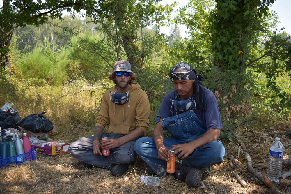 Volunteers rest between patrols of the burned out countryside (James Reynolds/The Independent)