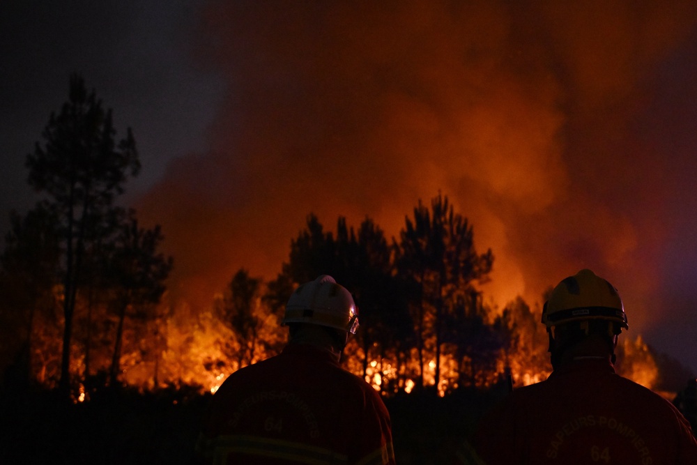 Firefighters battle a blaze outside Lanton, around 30 miles south of Lacanau (AP)