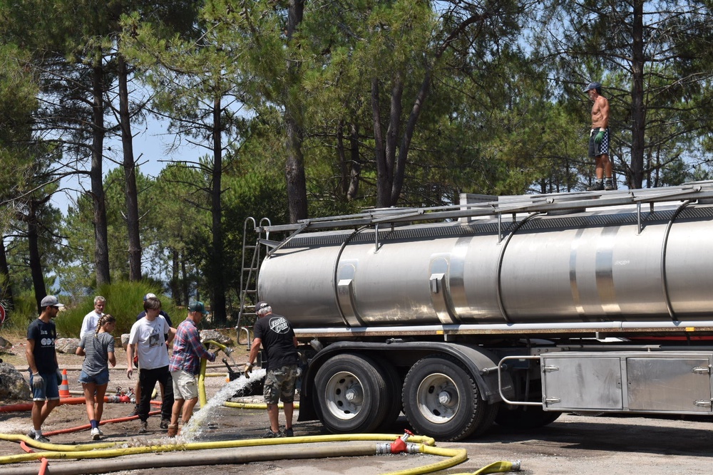 At the port, residents collect water to use in firefighting efforts in the forest (James Reynolds/The Independent)