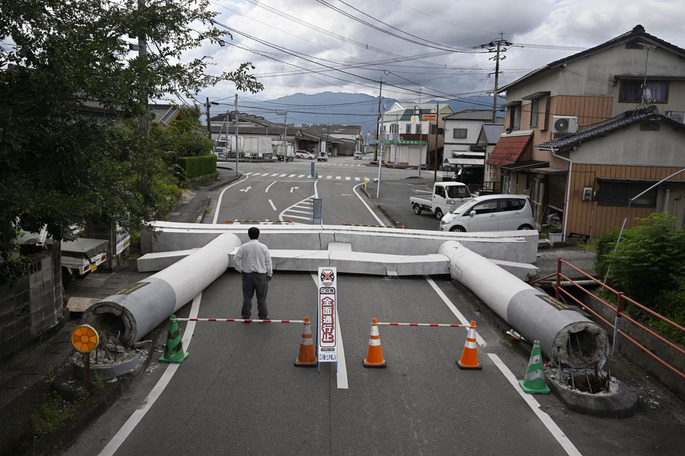 A man looks at a Torii gate that collapsed after an earthquake (Reuters)