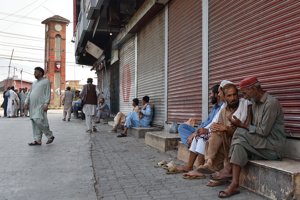 People gather near closed shops at a marketplace in Muzaffarabad, the capital of Pakistan-administered Kashmir on 16 June 2026 amid protests called by the Joint Awami Action Committee (JAAC) (AFP/Getty)