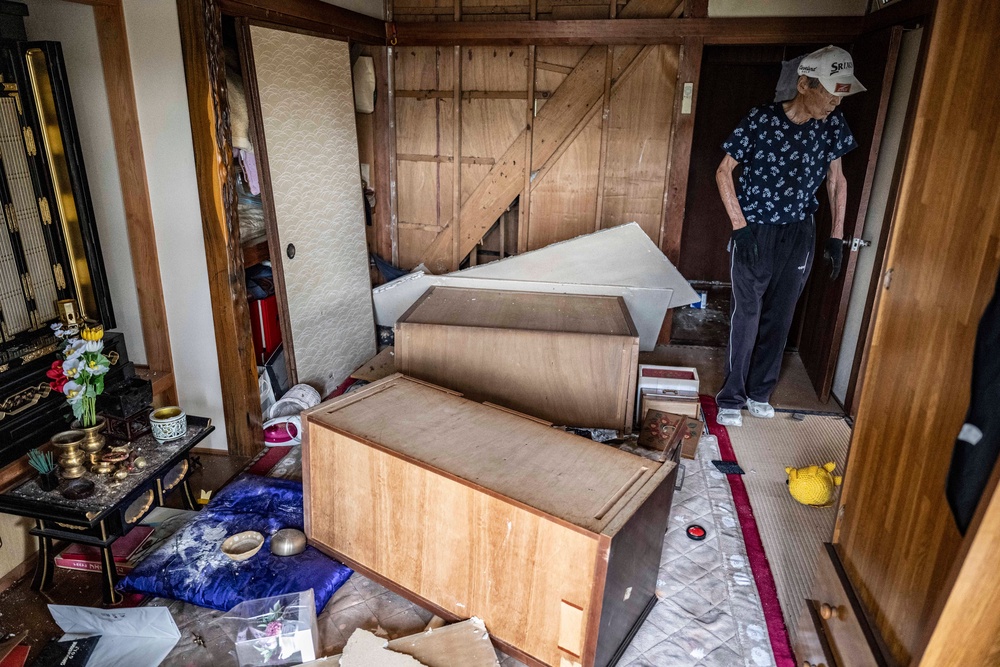 Akira Motoda walks inside his house damaged by a 7.1-magnitude earthquake in Uki city (AFP/Getty)