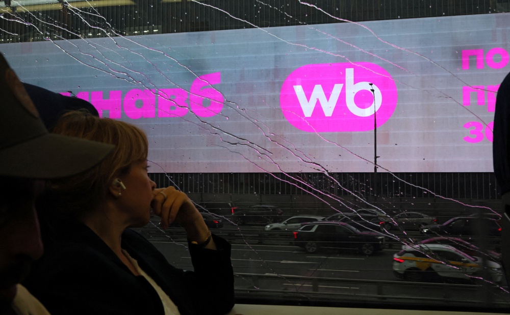 A woman rides a train past a screen advertising the Wildberries online retailer in Moscow, Russia 28 July 2026 (Reuters)