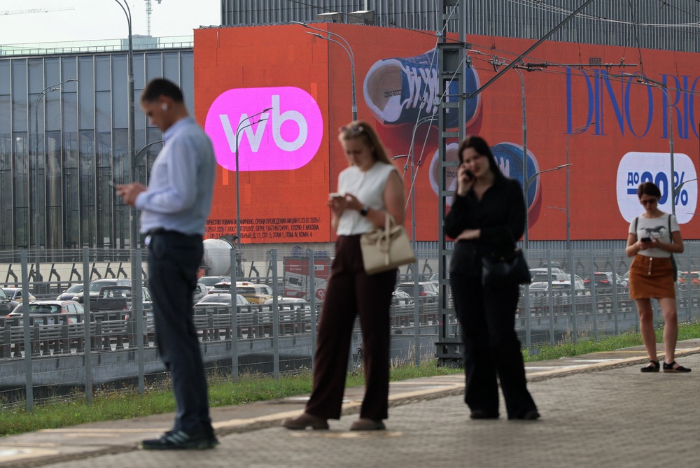 People wait for a train near a screen advertising the Wildberries online retailer in Moscow, Russia, 28 July 2026 (Reuters)