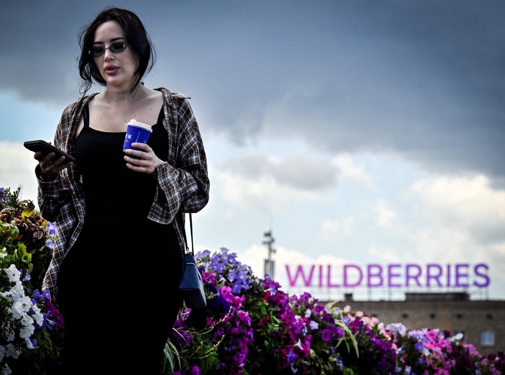 A woman walks past Russian e-commerce giant Wildberries' logo in downtown Moscow on 27 July 2026 (AFP/Getty)