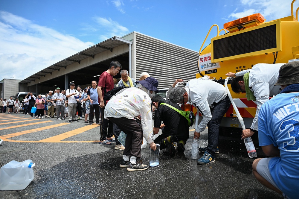 People line up to collect water from a supply truck at the city hall in Uki city, Kumamoto Prefecture (AFP/Getty)