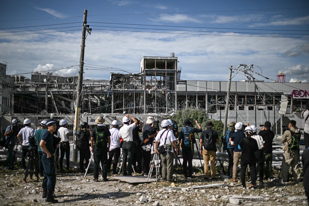 Journalists gather outside the damaged Aeon Mall Kumamoto in Kashima, Kumamoto Prefecture (AFP/Getty)