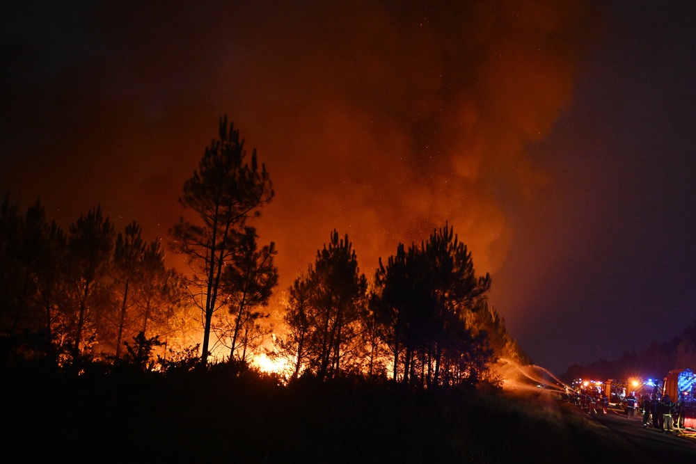 Firefighters battle a blaze outside Lanton, during wildfires in southwestern France, (AP)