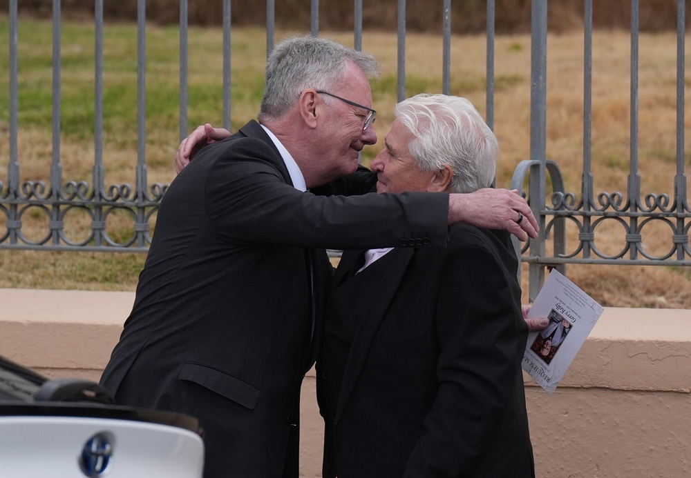 Mike Nesbitt (left) and John Linehan embrace outside the church (Niall Carson/PA) (PA Wire)