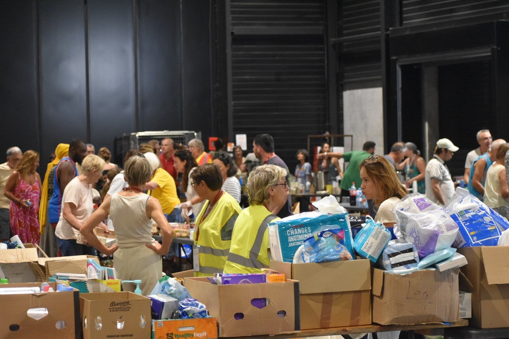 People hand out essentials at the busy centre for displaced persons in Bordeaux on Tuesday (James Reynolds / The Independent)