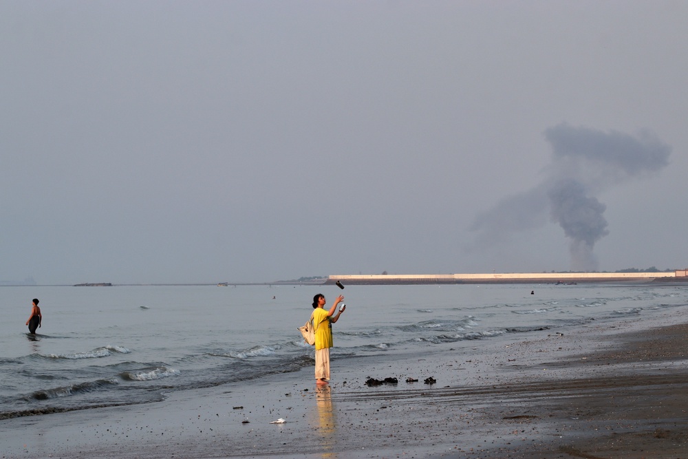 A woman stands at the water’s edge along the Strait of Hormuz, as many feel that Trump’s war with Iran is hurting their bank accounts (AP)