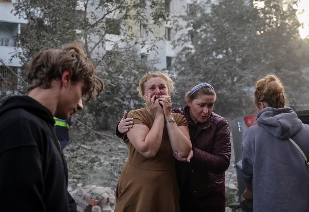 A woman reacts near an apartment building hit by a Russian missile strike, amid Russia's attack on Ukraine, in Lviv, Ukraine (Reuters)