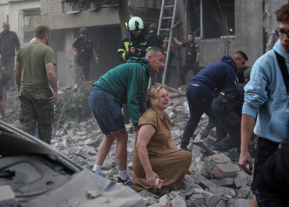 A woman reacts near an apartment building hit by a Russian missile strike, amid Russia's attack on Ukraine (Reuters)