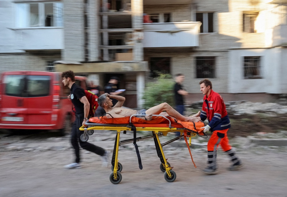 Medical workers evacuate a wounded resident at the site of an apartment building hit by a Russian missile strike (Reuters)