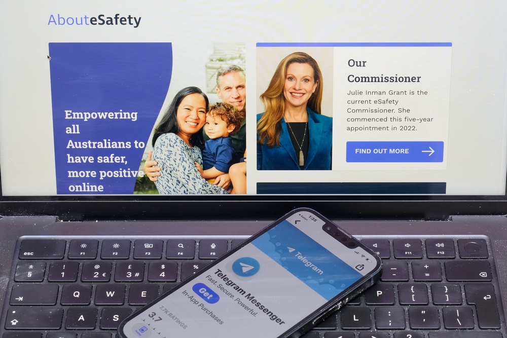 A phone rests on a computer showing the Australian eSafety web page in Sydney, Thursday, 30 July 2026 (AP)