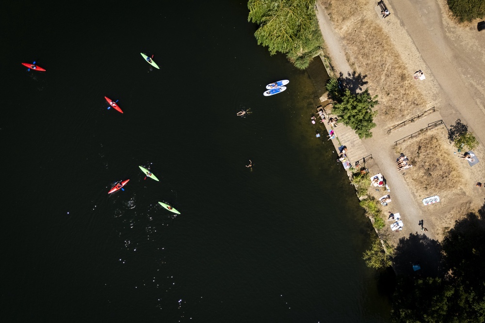 People sunbathing and swimming in the Thames at Ham, in London (PA) (PA Wire)