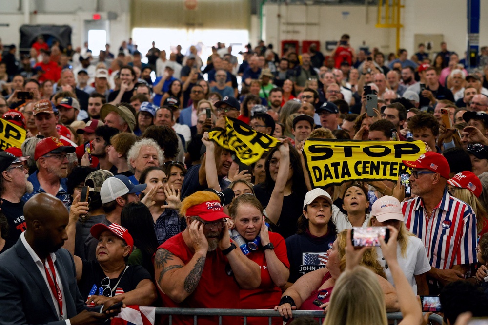 Protestors hold up 'Stop data centers' signs, on the day of Trump's speech in Michigan (Reuters)