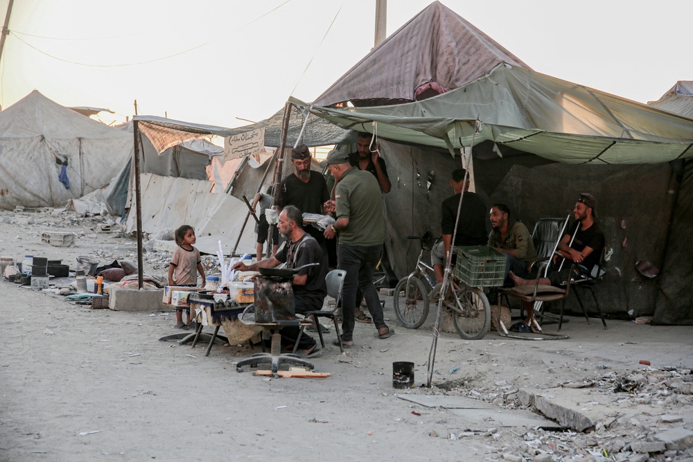 People gather at a makeshift stall in a camp along Al-Rasheed Street in west Gaza City (AFP/Getty)