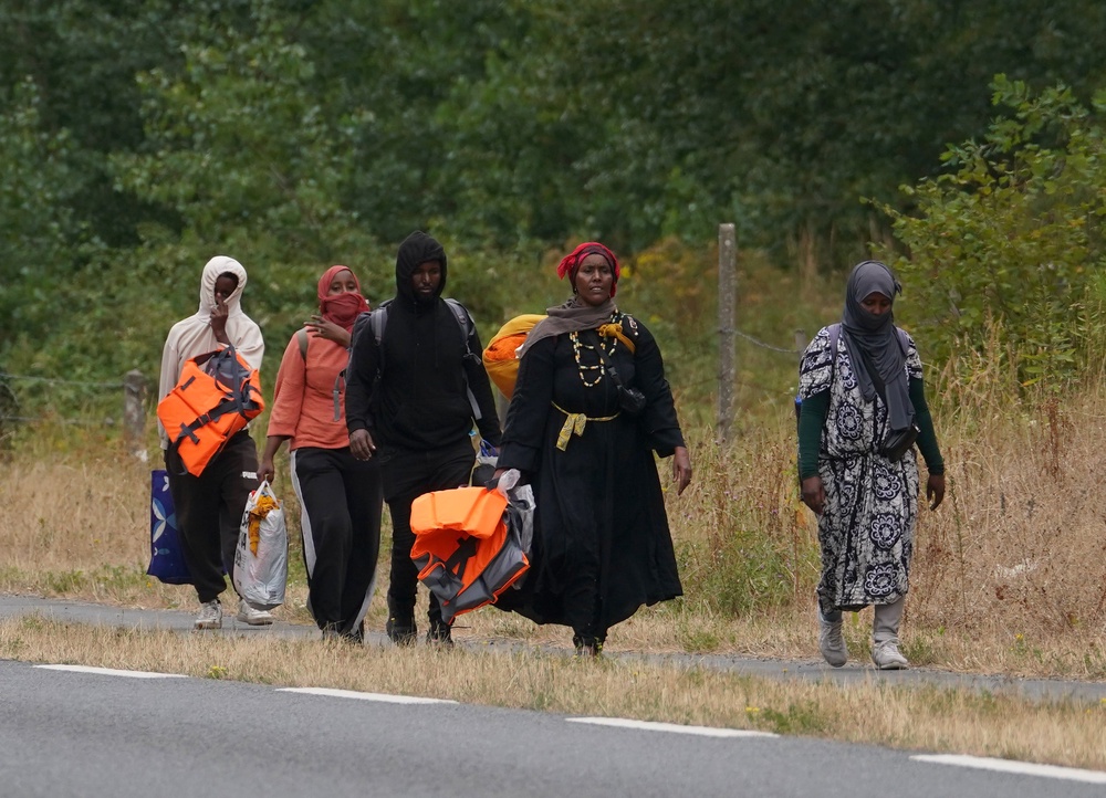 Migrants were seen walking along the side of the road near Hardelot in France on Thursday carrying life jackets (Gareth Fuller/PA) (PA Wire)