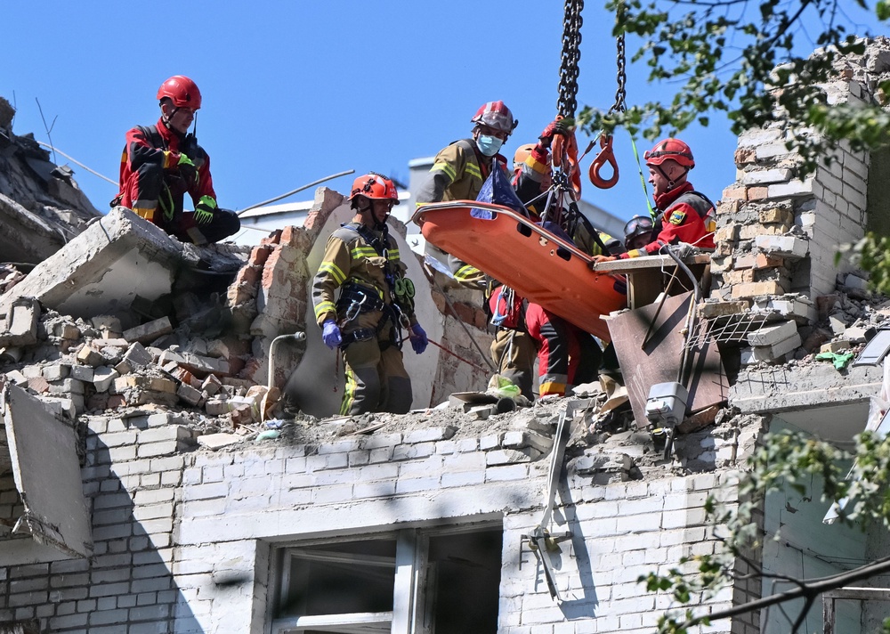 Rescuers use a crane to carry the body of someone killed during Russian strikes on Lviv (Reuters)
