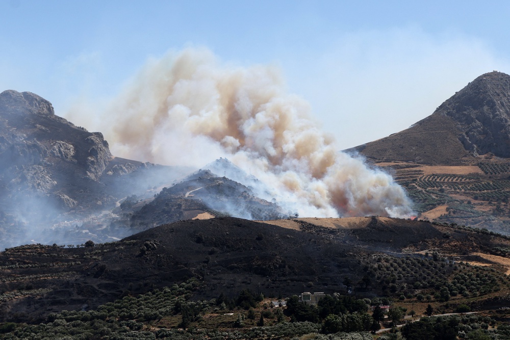 A wildfire burns in a canyon near Asomatos village on the island of Crete, Greece (Reuters)