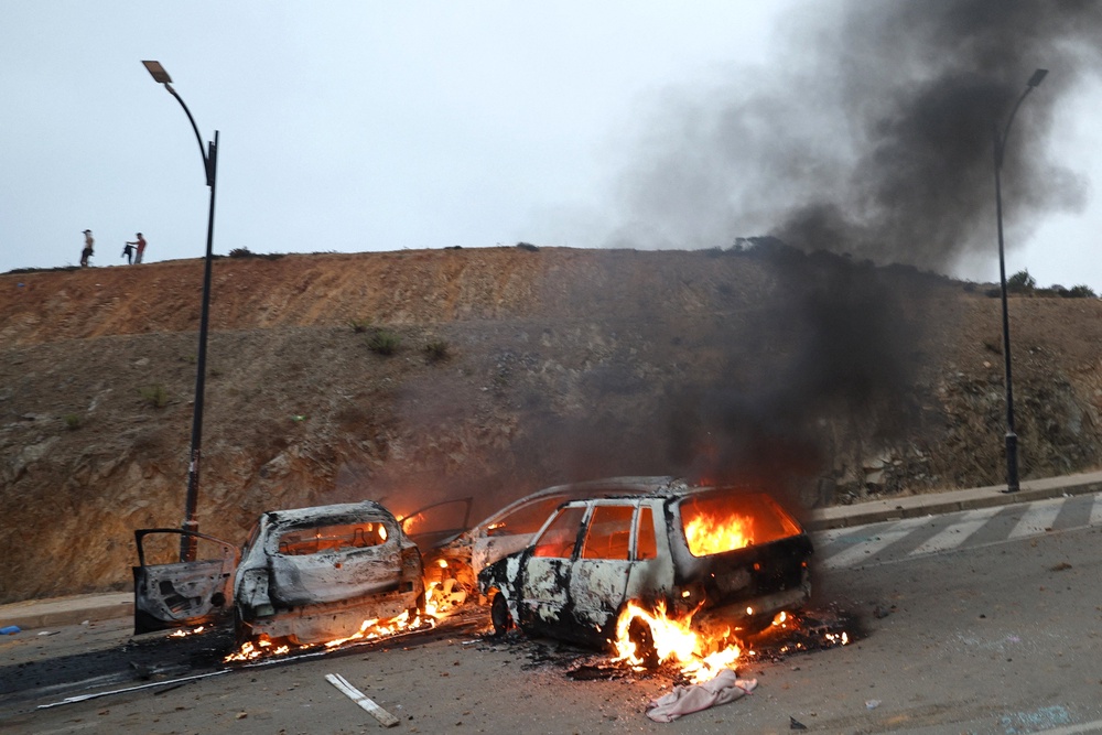 Vehicles burn at the site of clashes near Fnideq, on the Morocco-Spain border (AFP/Getty)