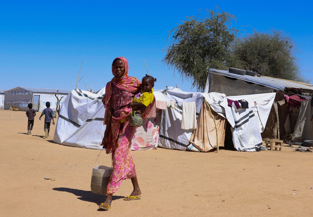 A Sudanese refugee woman from Al-Fashir carries a child in the a transit refugee camp in eastern Chad. (Reuters)