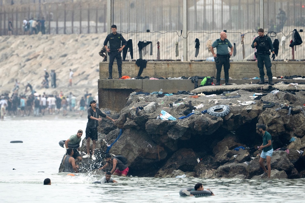 Migrants try to swim through the waters close to the border with Morocco to enter Spain's north Africa's Ceuta enclave as security forces observe on July 31, 2026. (Photo by JORGE GUERRERO / AFP via Getty Images) (AFP/Getty)