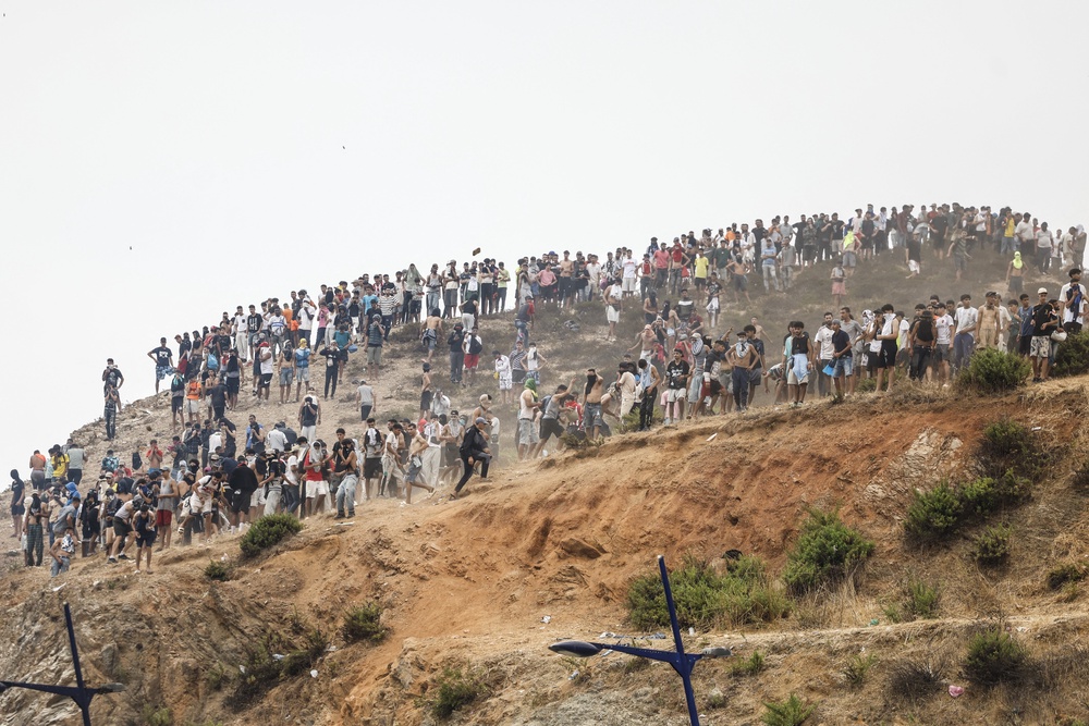 Migrants attempting to cross into Ceuta gather on a hilltop during clashes with Moroccan security forces (AFP/Getty)