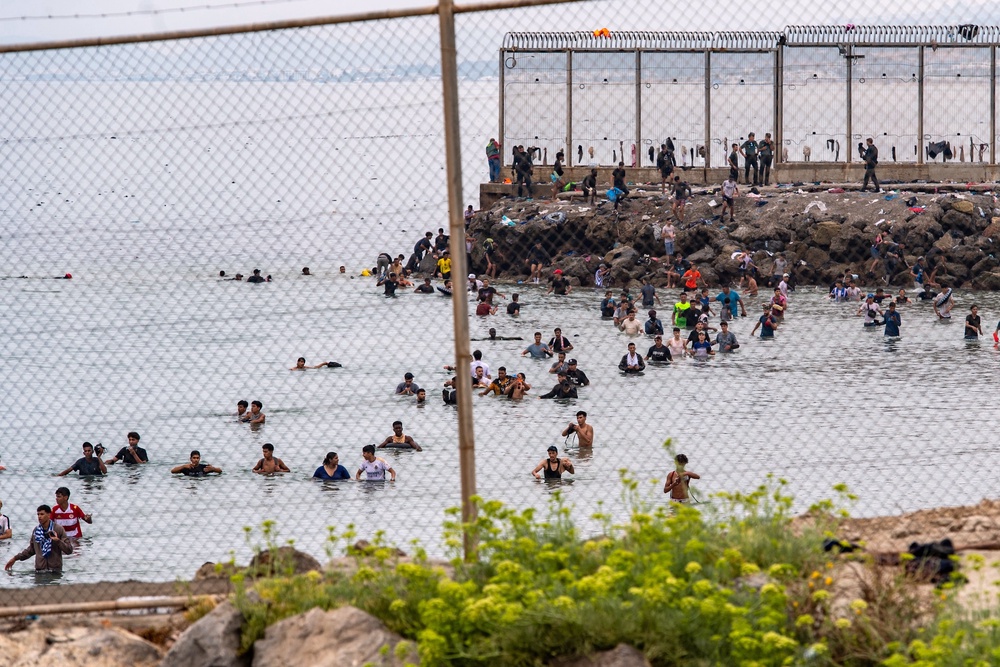 Of the 60,000 people who crossed between Thursday and Friday morning, some 45,000 had returned to Moroccan territory within hours after many spent the night on the streets of Ceuta amid startled locals and armed Spanish police and soldiers (Associated Press)